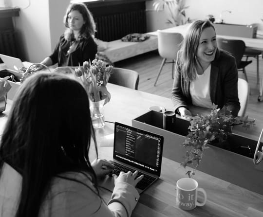 3 people sitting in an office environment